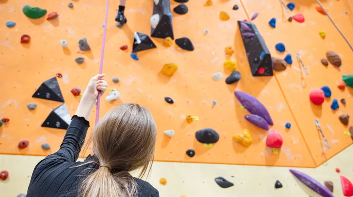 Eine Person schaut nach oben beim Sichern und unterstützt ihre Kletterparnerin. | © DAV-WR